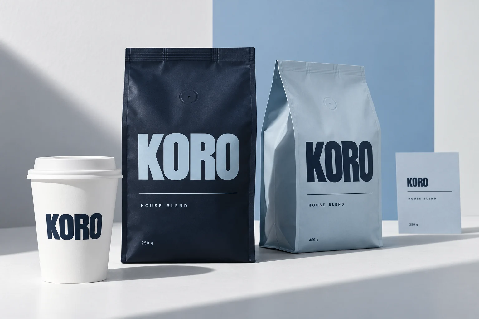 KORO midnight navy and powder blue coffee bags with a branded white takeaway cup and roast information card